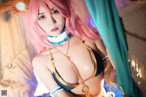 A woman with pink hair wearing a bikini and bunny ears.