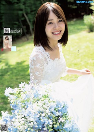 A woman in a white dress standing in the grass.