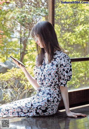 A woman wearing glasses standing in front of a window.