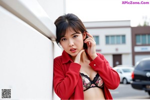 A woman in a pink kimono sitting on a window sill.