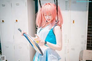 A woman with pink hair wearing a blue and white outfit.