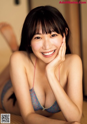A woman in a blue bikini posing for a picture.
