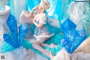 A woman dressed as Elsa from Frozen is posing for a picture.