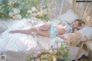 A woman in a white lingerie with flowers in her hair.