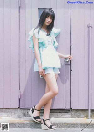 A woman in a white dress is featured in a magazine.
