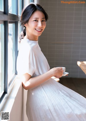 A woman sitting at a table with her hand on her chin.