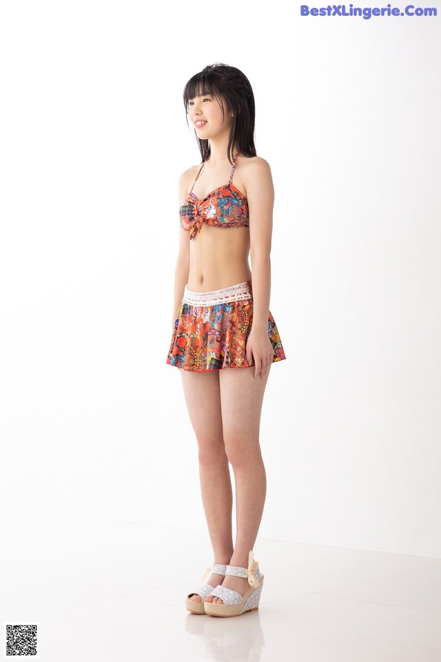 A woman in a bikini top and shorts posing for a picture.