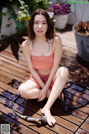 A woman in a pink bikini sitting on a white chair.