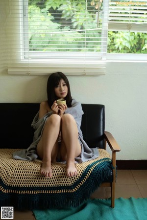A woman wrapped in a blanket on a bed.