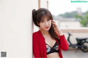 A woman in a red jacket and black bra posing for a picture.
