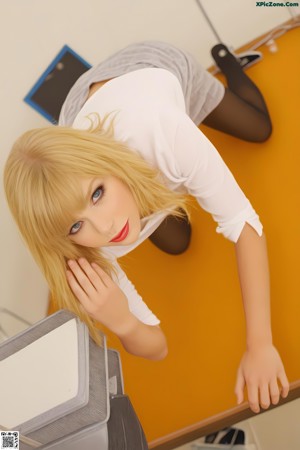 A woman in a white shirt and blue panties posing for a picture.