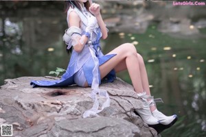 A woman in a blue and white outfit posing for a picture.