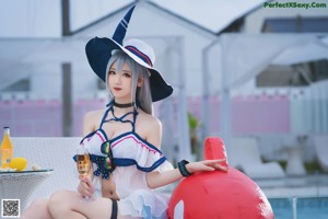 A woman in a sailor outfit sitting on a lounge chair.