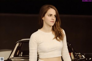 A woman in a yellow tank top holding a chocolate banana.