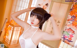 A woman in a white bathing suit sitting on the floor.