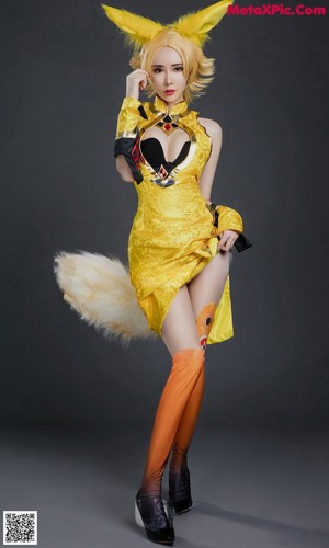 A woman in a yellow and black outfit is posing for a picture.