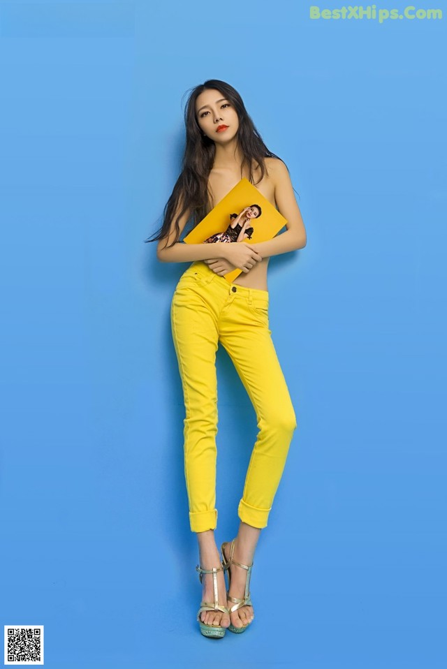 A woman in yellow pants and a yellow top posing for a picture.