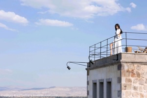 A woman sitting on a chair on top of a roof.