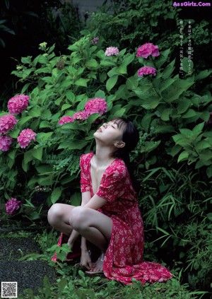 A woman in a black bra and panties posing for a magazine.