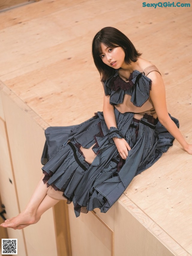 A woman sitting on top of a wooden box.