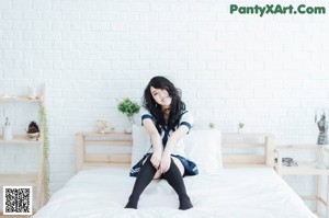 A woman sitting on the ground with her legs crossed.