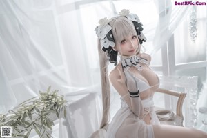A woman in a white lingerie posing for a picture.