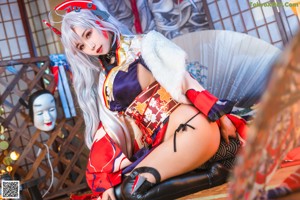 A woman in a kimono sitting on a chair.