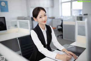 A woman sitting on a couch holding a piece of paper.