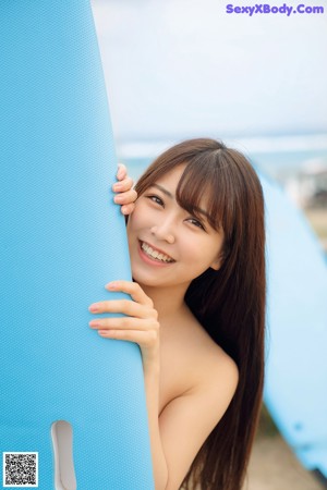 A woman in a white shirt is posing for a picture.
