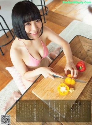 A woman in a pink bikini is preparing food in a kitchen.