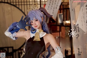 A naked woman with blue hair is posing for the camera.