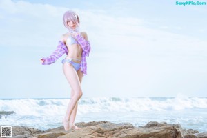 A woman in a bikini standing on a beach.