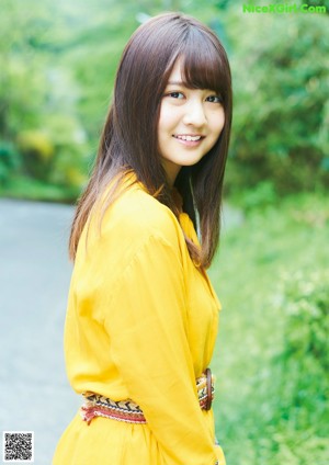 A woman in a yellow dress sitting on a swing.