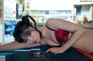 A woman laying on top of a table next to a keyboard.